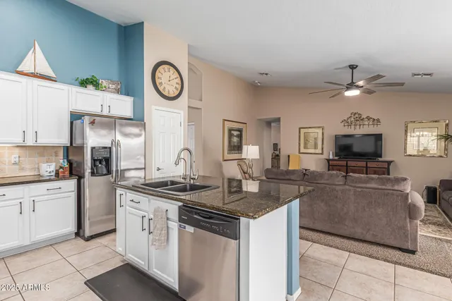 a kitchen with stainless steel appliances granite countertop a stove a sink and a refrigerator