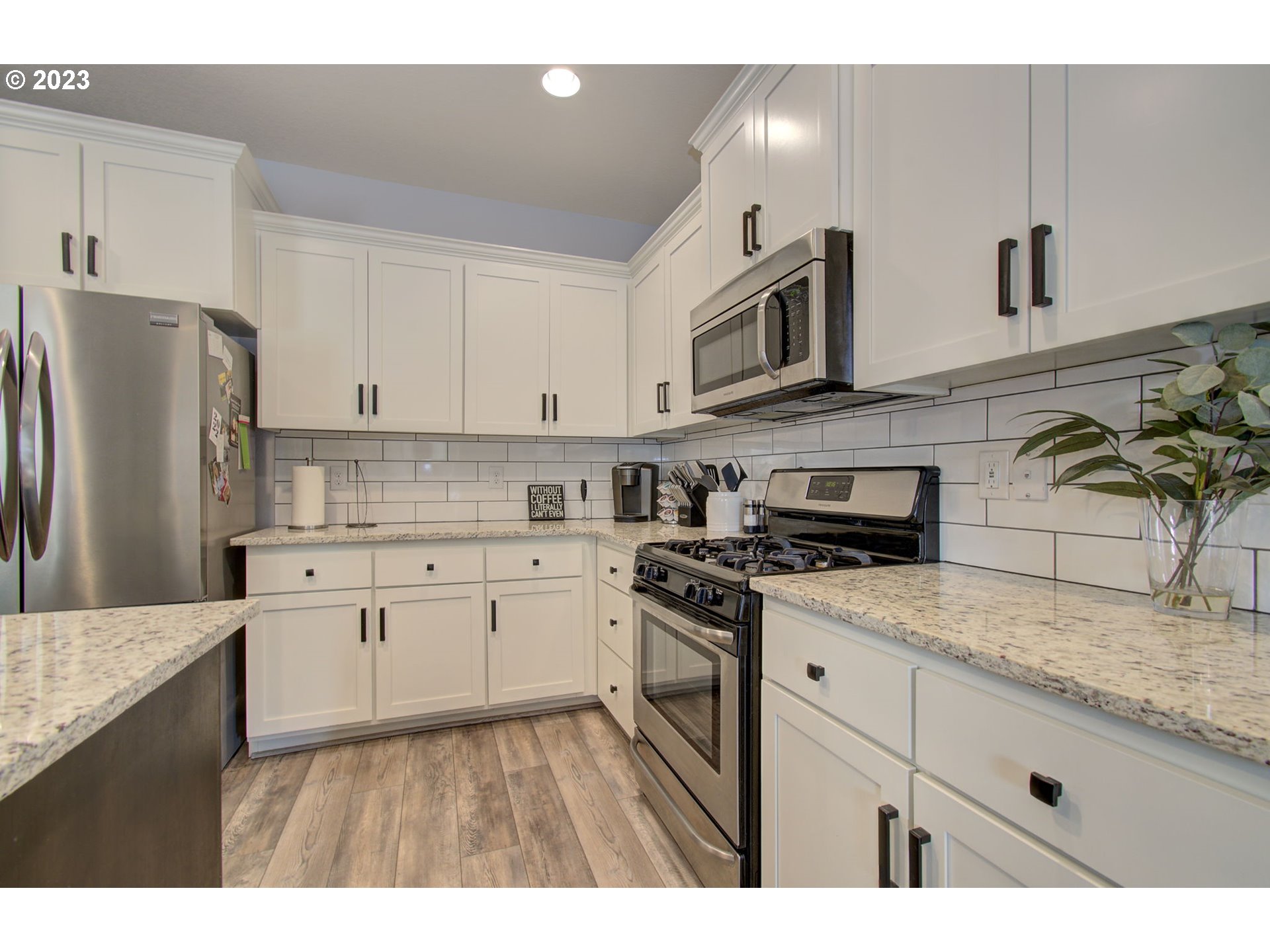 871 North 35th Avenue Ridgefield, WA 98642 - Photo 8 of 36 a kitchen with stainless steel appliances granite countertop a sink a stove a refrigerator and white cabinets