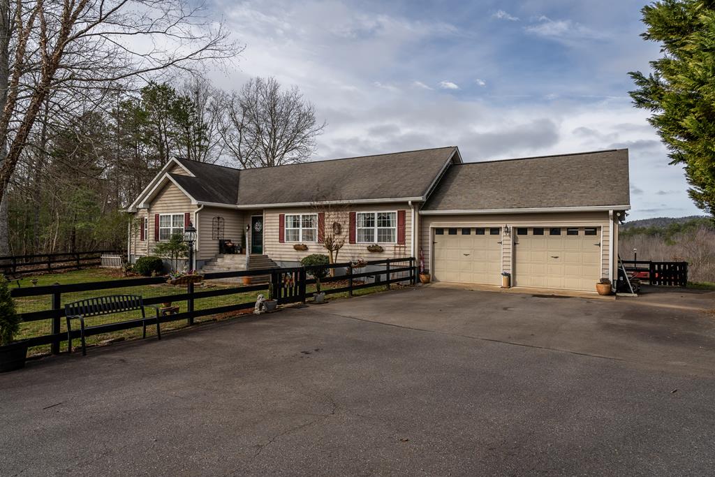 a view of a house with a yard and wooden fence