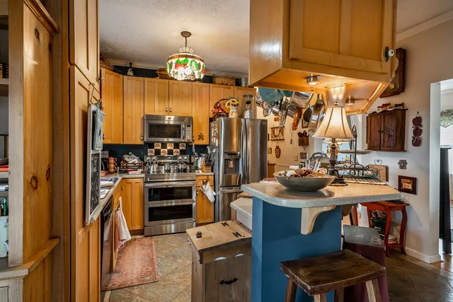 a kitchen with stainless steel appliances a stove a refrigerator and a sink