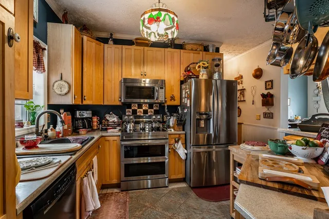 a kitchen with stainless steel appliances a stove a sink and a microwave