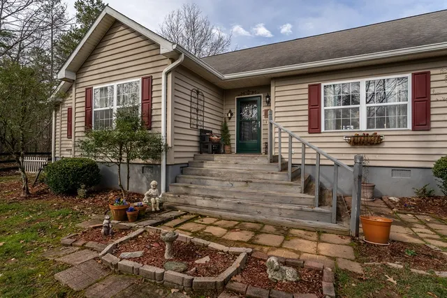 a view of a house with a yard chairs and a table