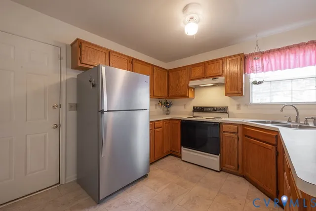 a kitchen with stainless steel appliances granite countertop a refrigerator and a sink