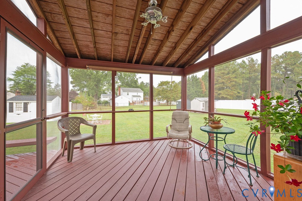 6332 Springcrest Lane Richmond, VA 23231 - Photo 30 of 38 a porch with a table and chairs next to a yard with wooden floor