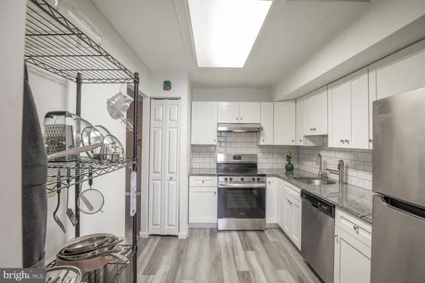 a kitchen with stainless steel appliances a stove a sink and a refrigerator
