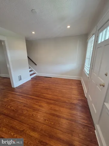 an empty room with wooden floor and a window