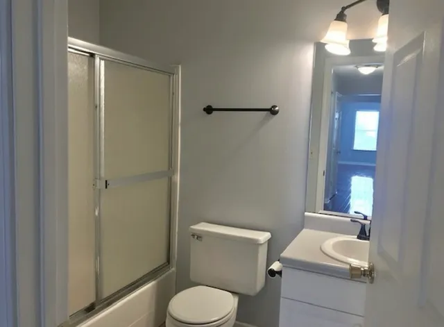 a bathroom with a toilet a sink and mirror