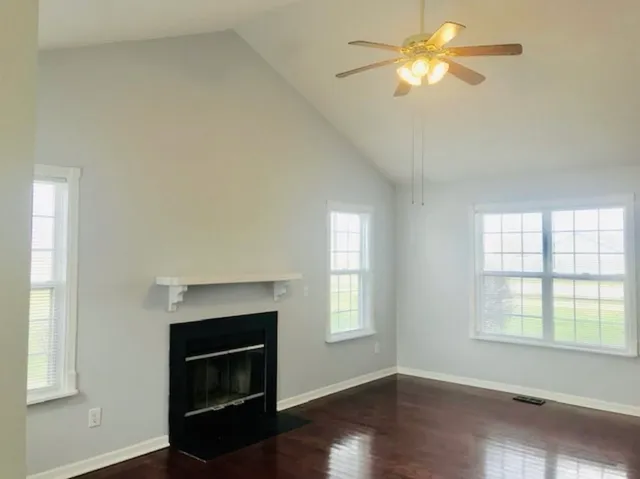 an empty room with windows and a fireplace