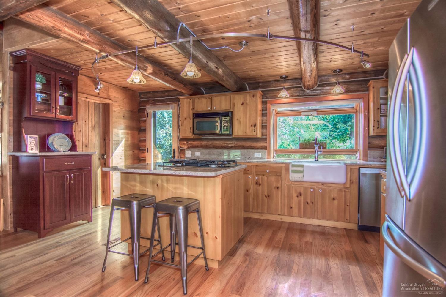 18762 Ridgecrest Road Bend, OR 97703 - Photo 5 of 25 a kitchen with stainless steel appliances granite countertop a refrigerator a sink dishwasher a stove and white countertops with wooden floor