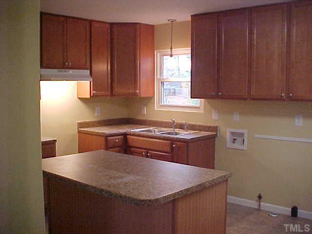 2309 Sheffield Road Raleigh, NC 27610 - Photo 5 of 7 a kitchen with stainless steel appliances granite countertop wooden cabinets a sink and a stove
