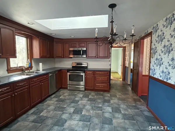 a kitchen with stainless steel appliances granite countertop a stove sink and cabinets