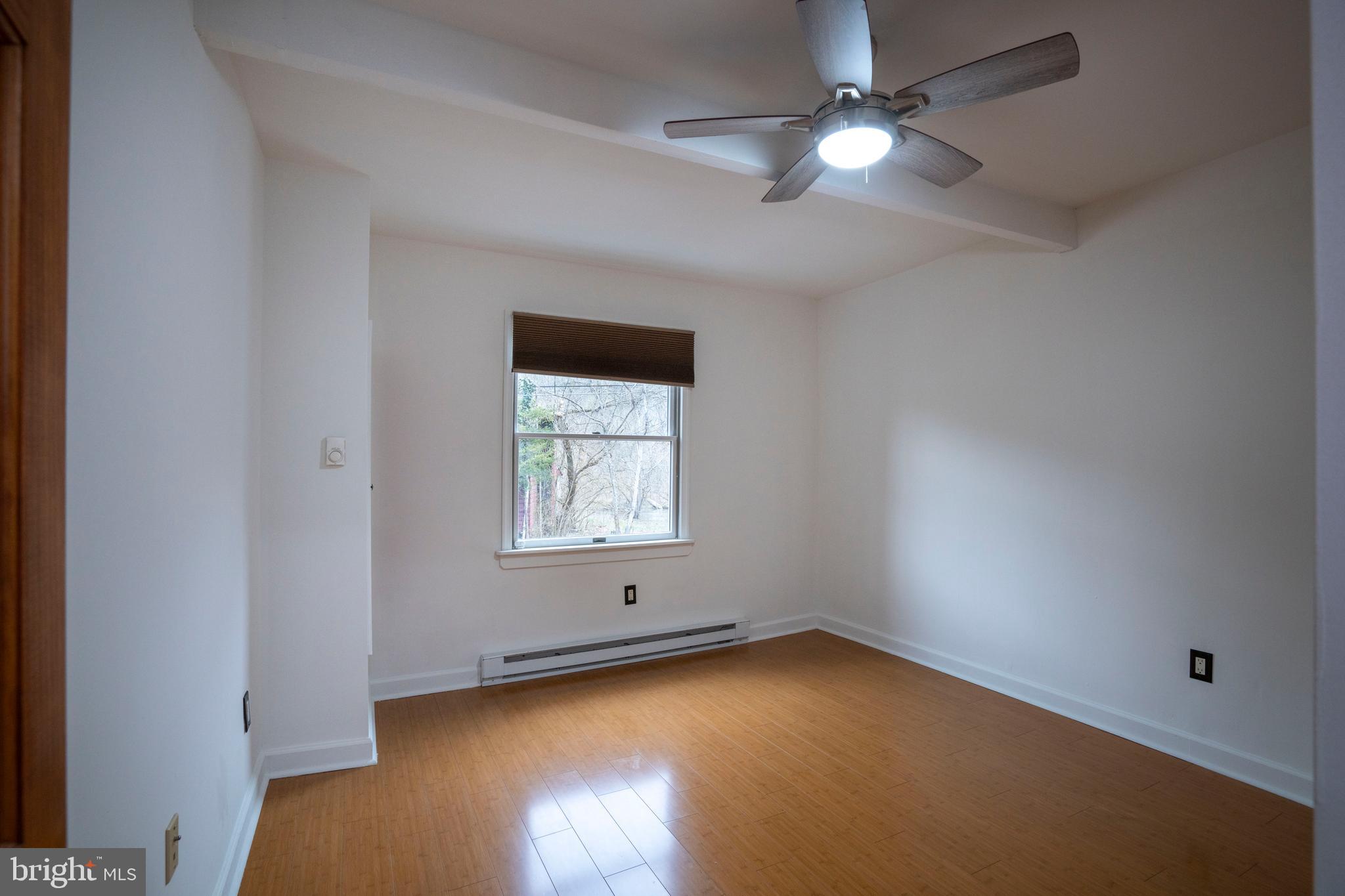 874 Spring Creek Road Bellefonte, PA 16823 - Photo 13 of 45 an empty room with a window and wooden floor