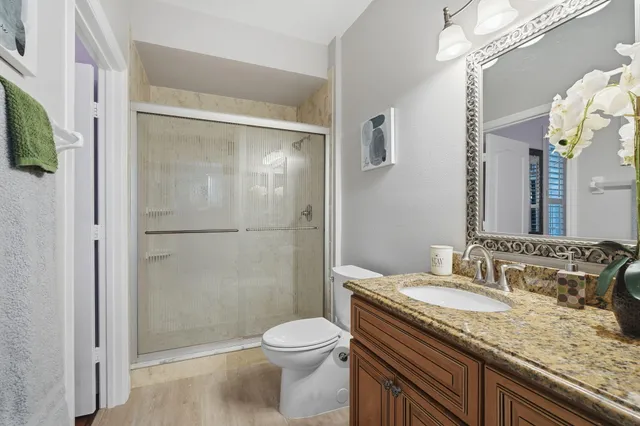 a bathroom with a granite countertop sink toilet and shower