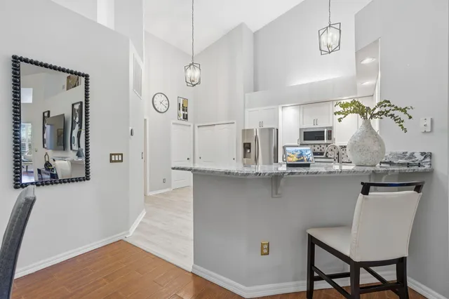 a kitchen with stainless steel appliances granite countertop a sink a stove and a wooden floors