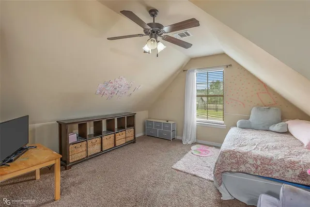 a bedroom with furniture and a chandelier fan