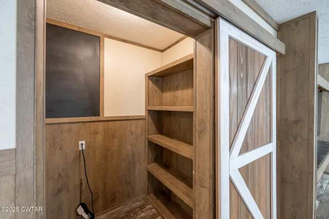 a view of a hallway with wooden floor staircase and a kitchen