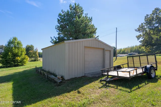 a view of an house with backyard and a tree