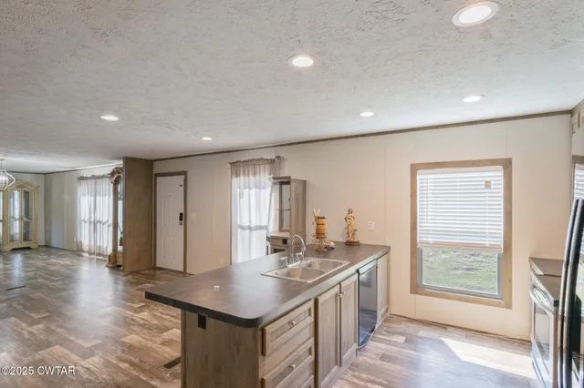 a kitchen with a sink cabinets and wooden floor