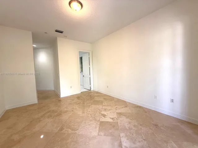 a view of an empty room with glass door and windows