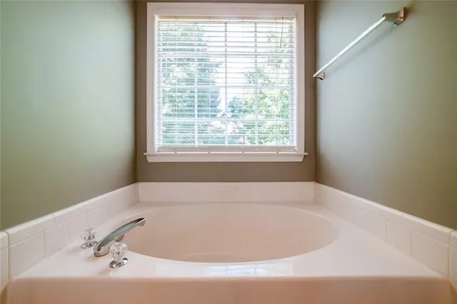a white bath tub sitting in a bathroom next to a window