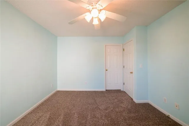 a view of a room with a ceiling fan and a window