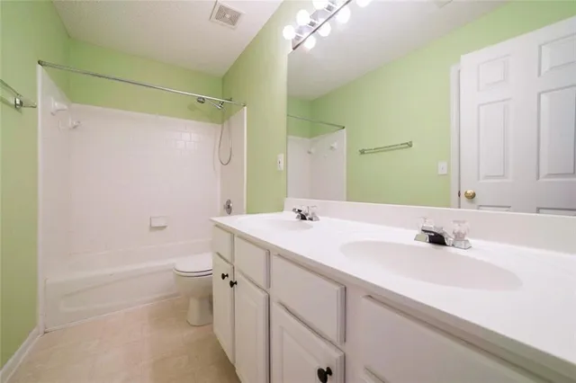 a bathroom with a sink a toilet a mirror a vanity and shower