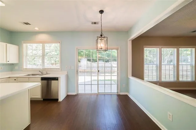 a kitchen with a large window wooden floor and stainless steel appliances