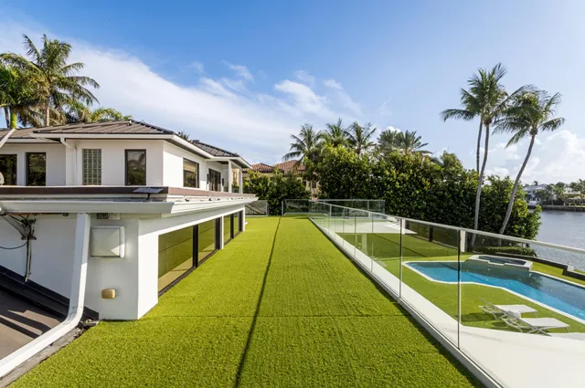 a living room with furniture a large window and potted plants