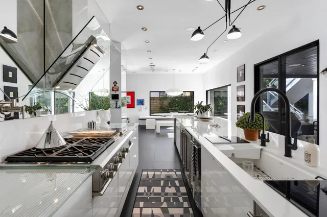 a kitchen with stainless steel appliances granite countertop a sink a stove and a refrigerator