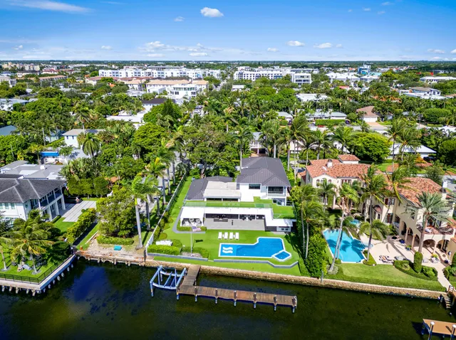a front view of a house with a yard and potted plants
