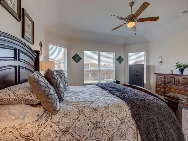 a bedroom with a large bed and a chandelier