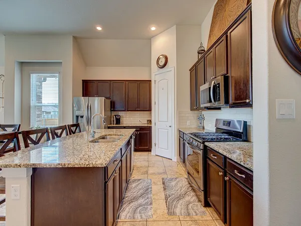 a kitchen with stainless steel appliances granite countertop a sink stove and refrigerator