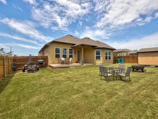a backyard of a house with table and chairs