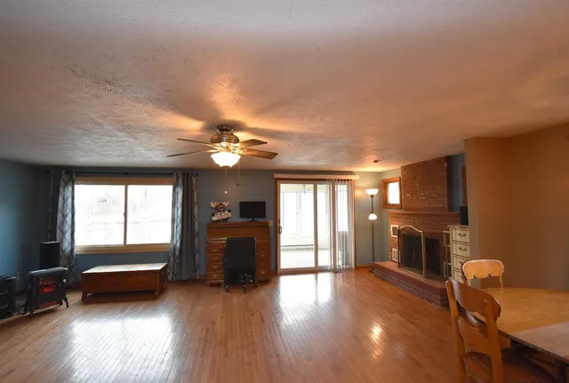 a view of a livingroom with furniture a hardwood floor and a ceiling fan