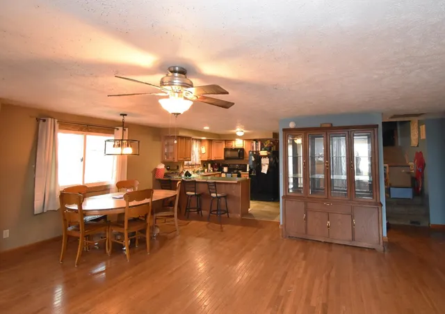 a dining room with furniture a chandelier and wooden floor