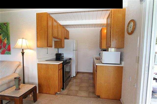 215 Maia Road Hana, HI 96713 - Photo 11 of 23 a kitchen with a stove a refrigerator and a table
