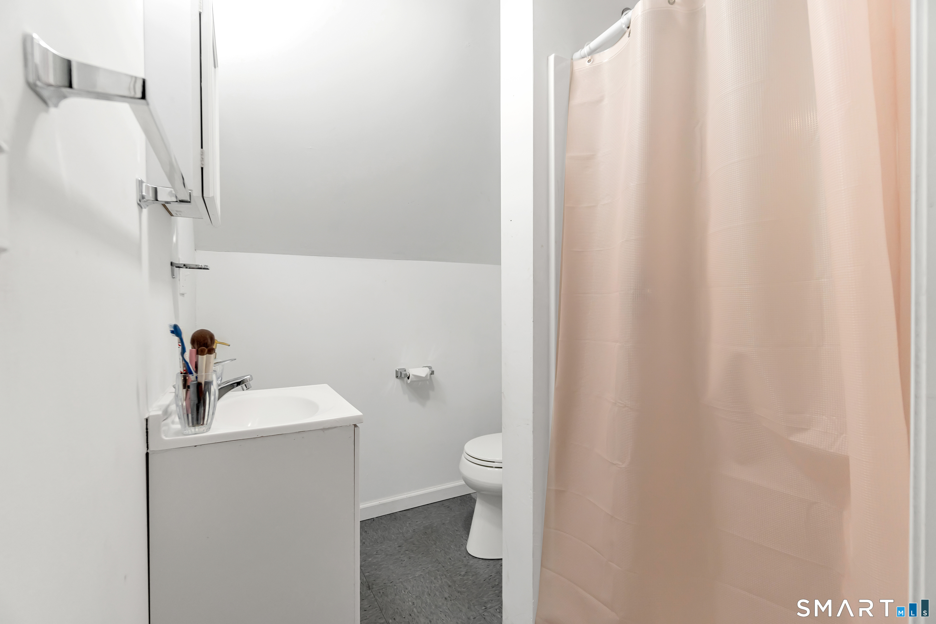 214 Thames Street New London, CT 06320 - Photo 18 of 33 a bathroom with a sink a toilet and shower curtain