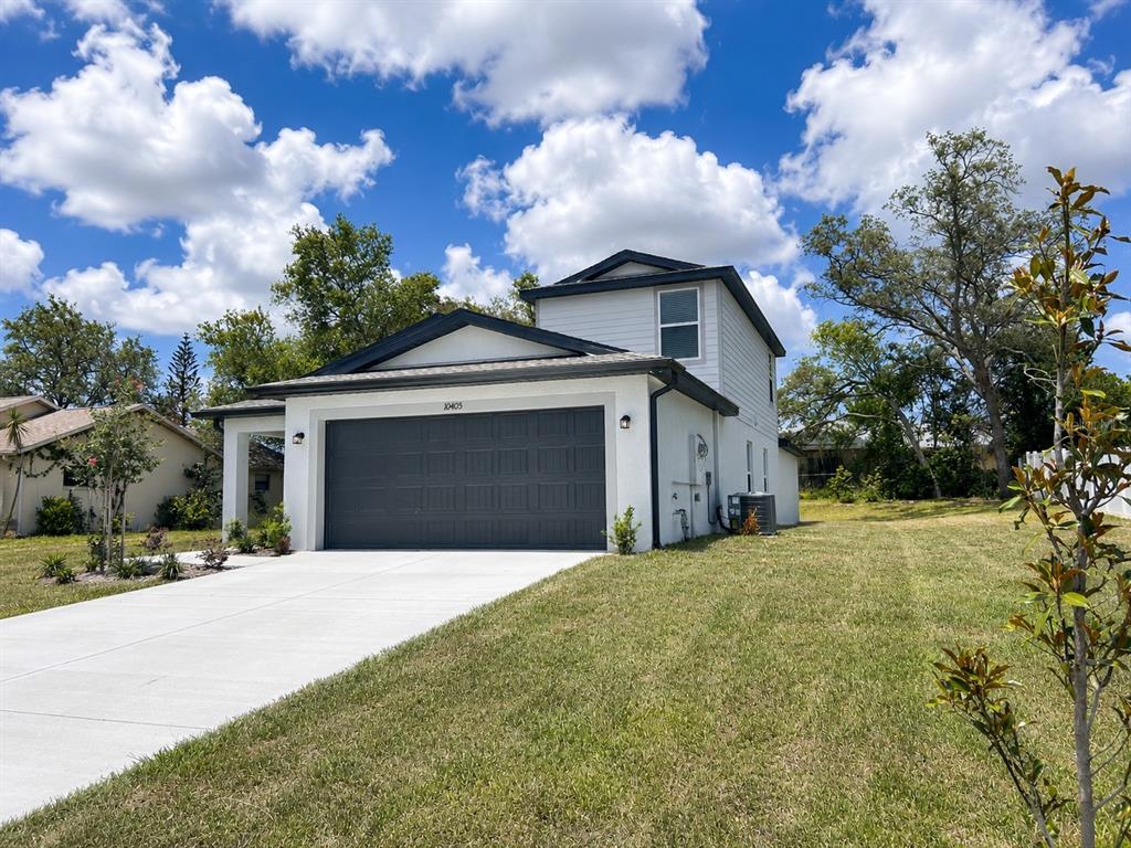 10405 Timbercrest Road Spring Hill, FL 34608 - Photo 2 of 14 a front view of a house with a yard and garage