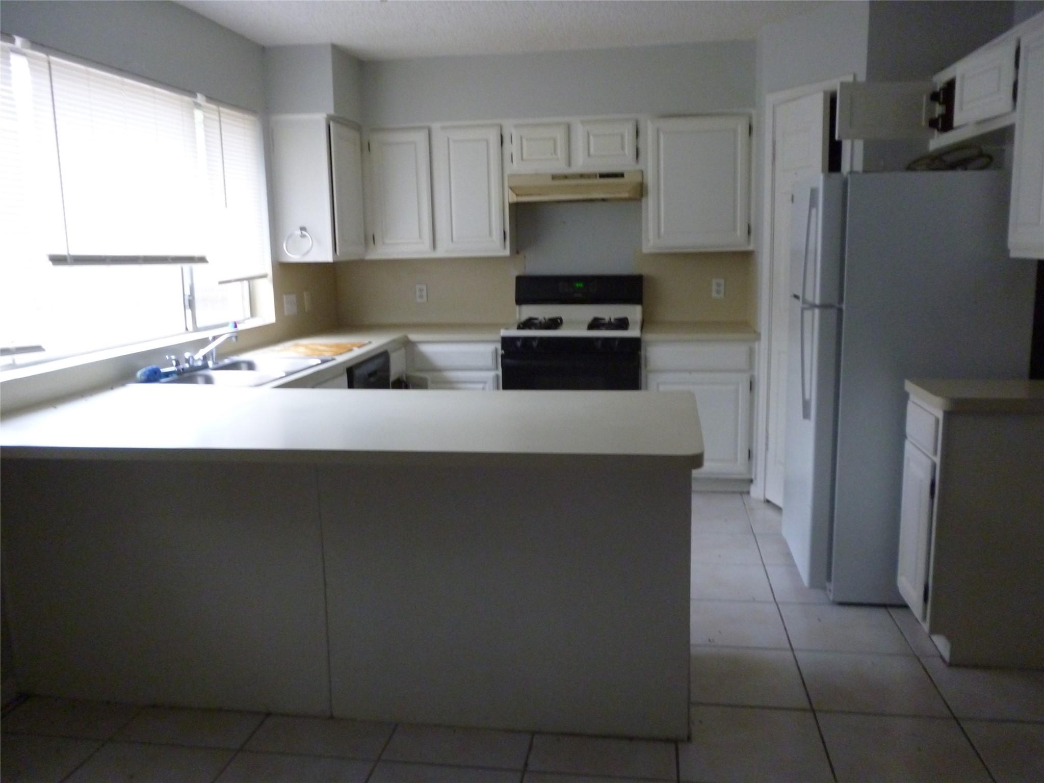 3243 Battle Ridge Lane Sugar Land, TX 77479 - Photo 23 of 34 a kitchen with a sink a refrigerator and a stove