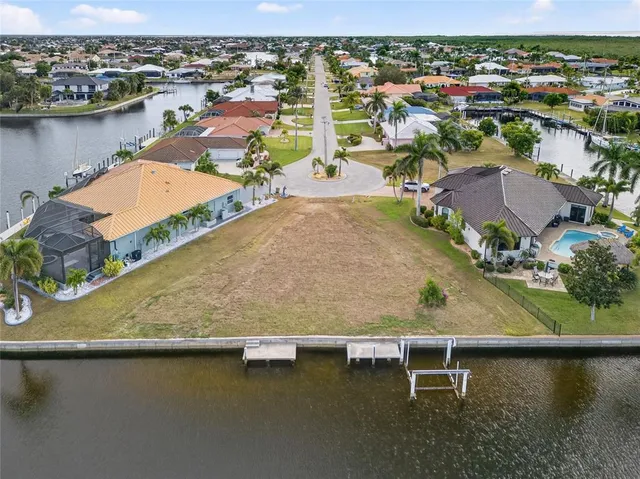 an aerial view of residential houses with outdoor space and lake view