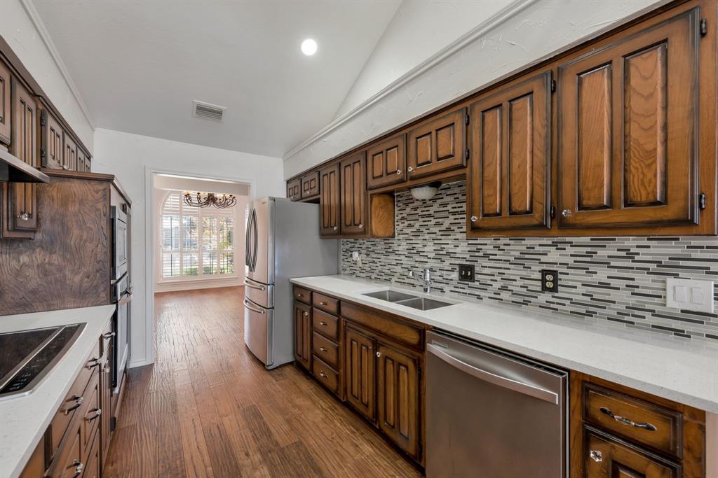 3305 Timber View Circle Bedford, TX 76021 - Photo 11 of 26 a kitchen with stainless steel appliances granite countertop hardwood floor sink stove and wooden cabinets