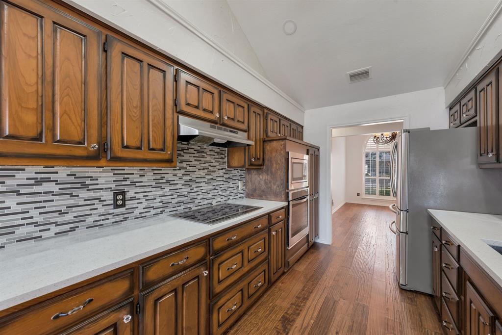 3305 Timber View Circle Bedford, TX 76021 - Photo 12 of 26 a kitchen with stainless steel appliances granite countertop a refrigerator and wooden cabinets