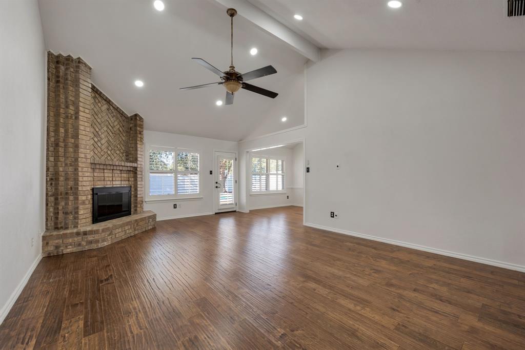 3305 Timber View Circle Bedford, TX 76021 - Photo 16 of 26 an empty room with wooden floor fireplace and windows