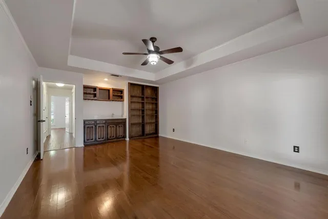 a view of a room with wooden floor and ceiling fan