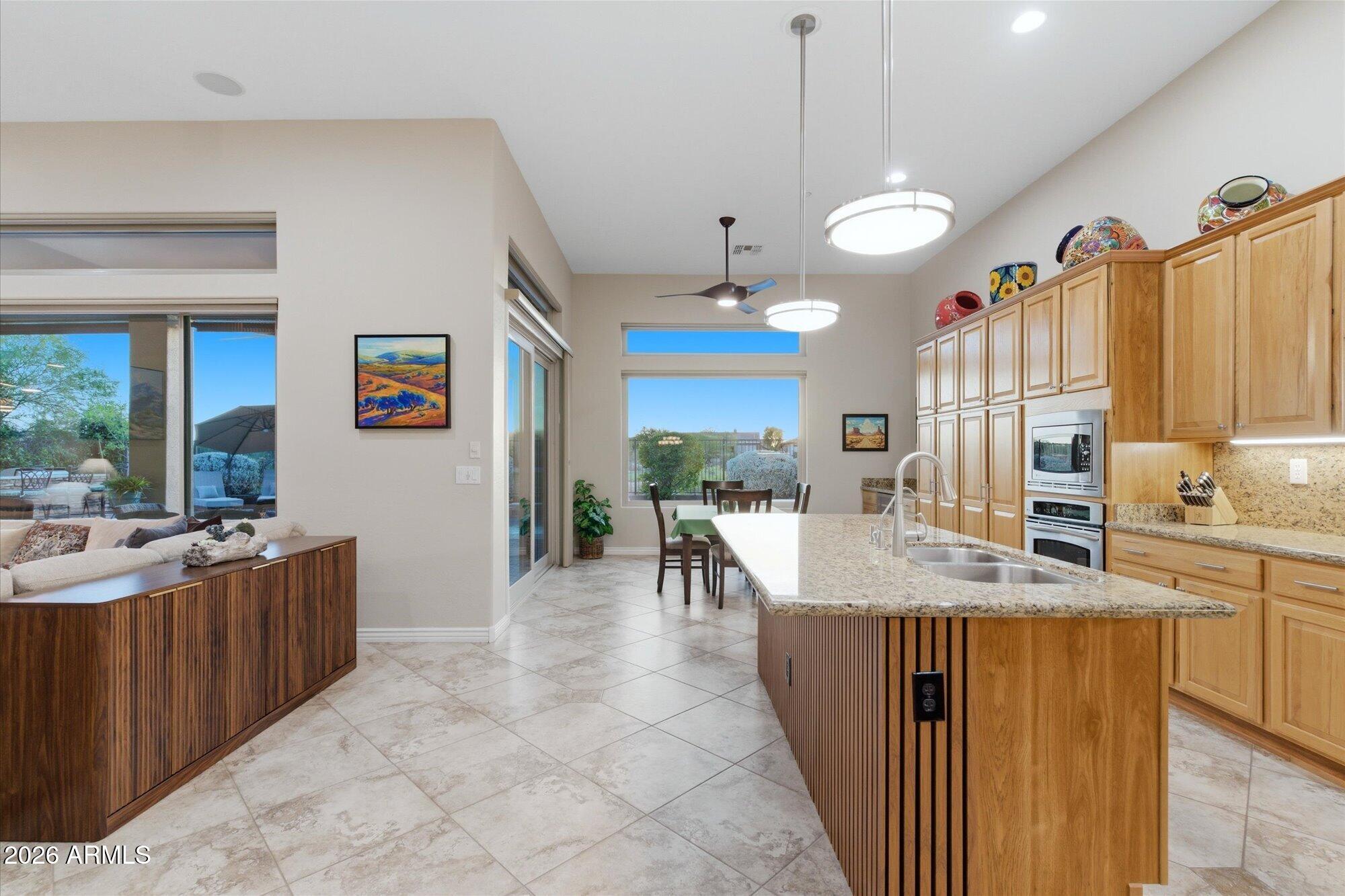 40322 North Hawk Ridge Trail Anthem, AZ 85086 - Photo 18 of 63 a large kitchen with kitchen island a large counter top space appliances and a view of living room