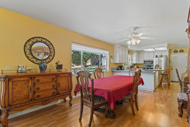 a kitchen with stainless steel appliances a refrigerator a stove a sink dishwasher and white cabinets with wooden floor