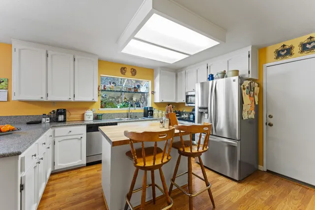 a bathroom with a granite countertop toilet sink and mirror