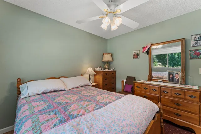 a bed room with a bed mirror on dresser and a window
