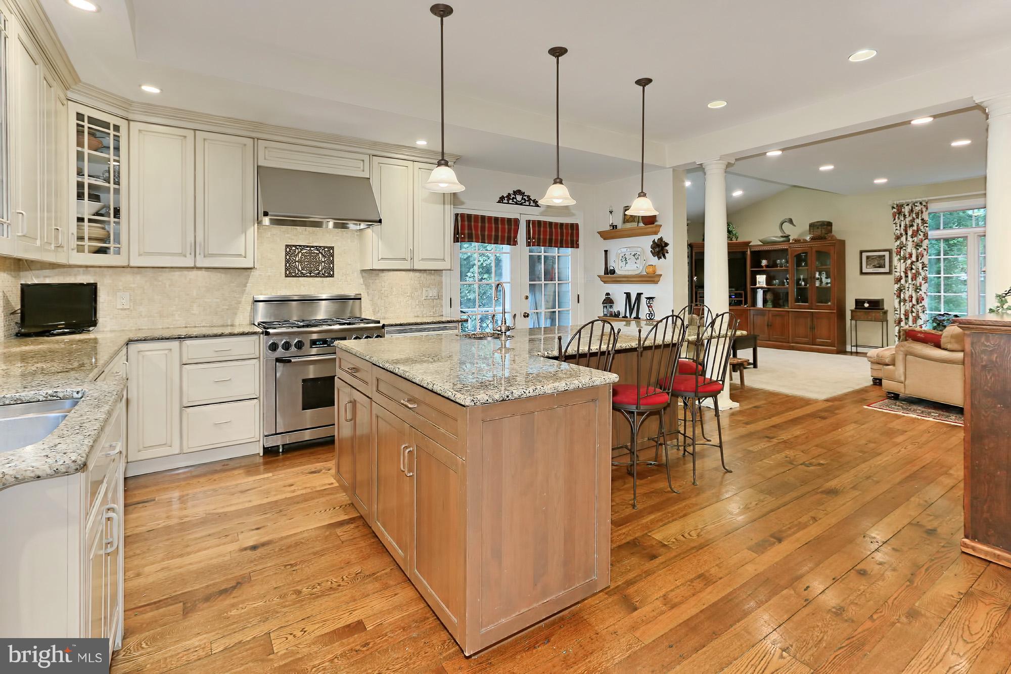 6729 Surbiton Drive Clifton, VA 20124 - Photo 8 of 25 a kitchen with stainless steel appliances granite countertop a stove top oven a sink dishwasher a dining table and chairs with wooden floor