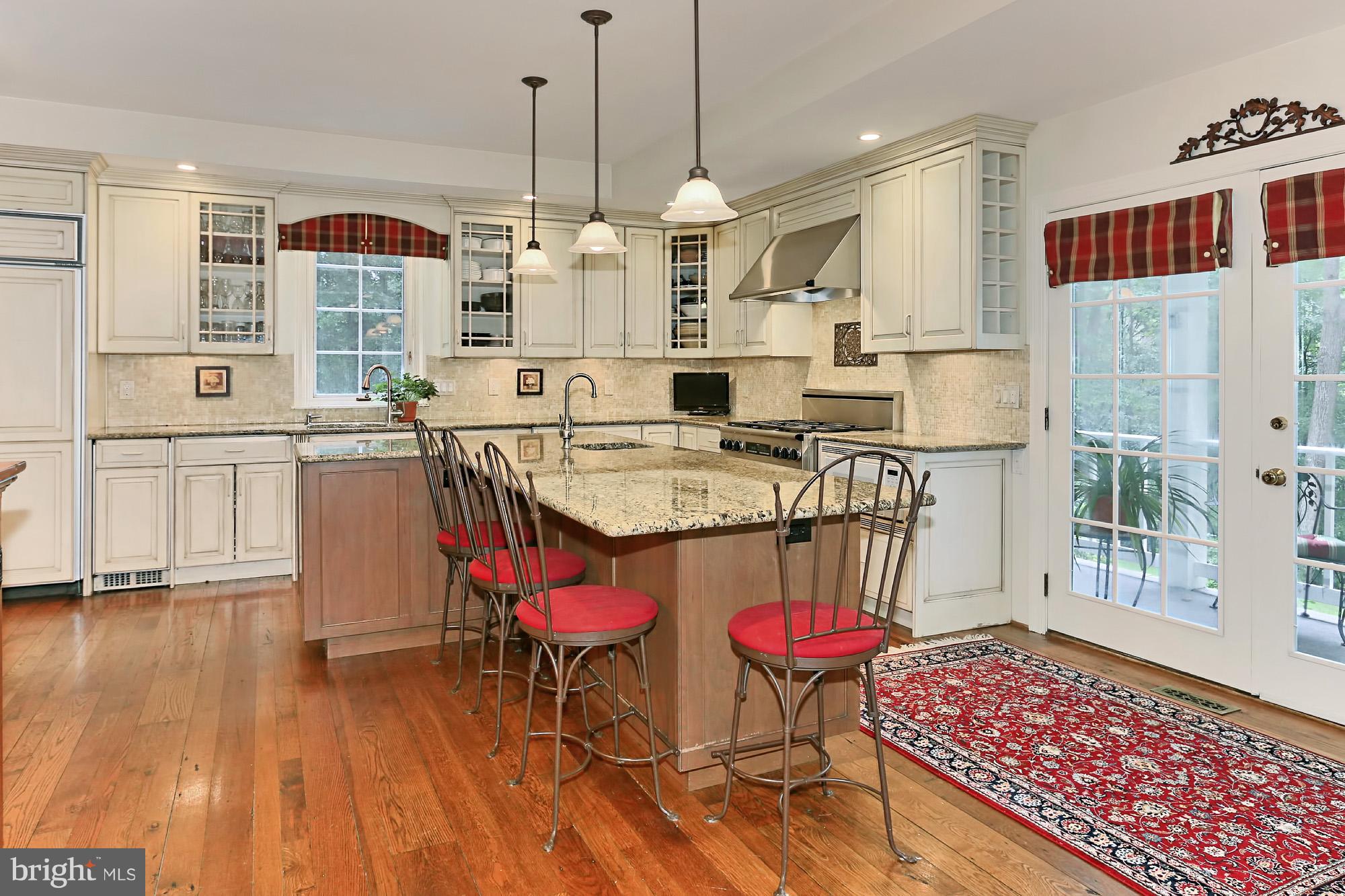 6729 Surbiton Drive Clifton, VA 20124 - Photo 10 of 25 a open kitchen with stainless steel appliances granite countertop a stove top oven a dining table and chairs with wooden floor